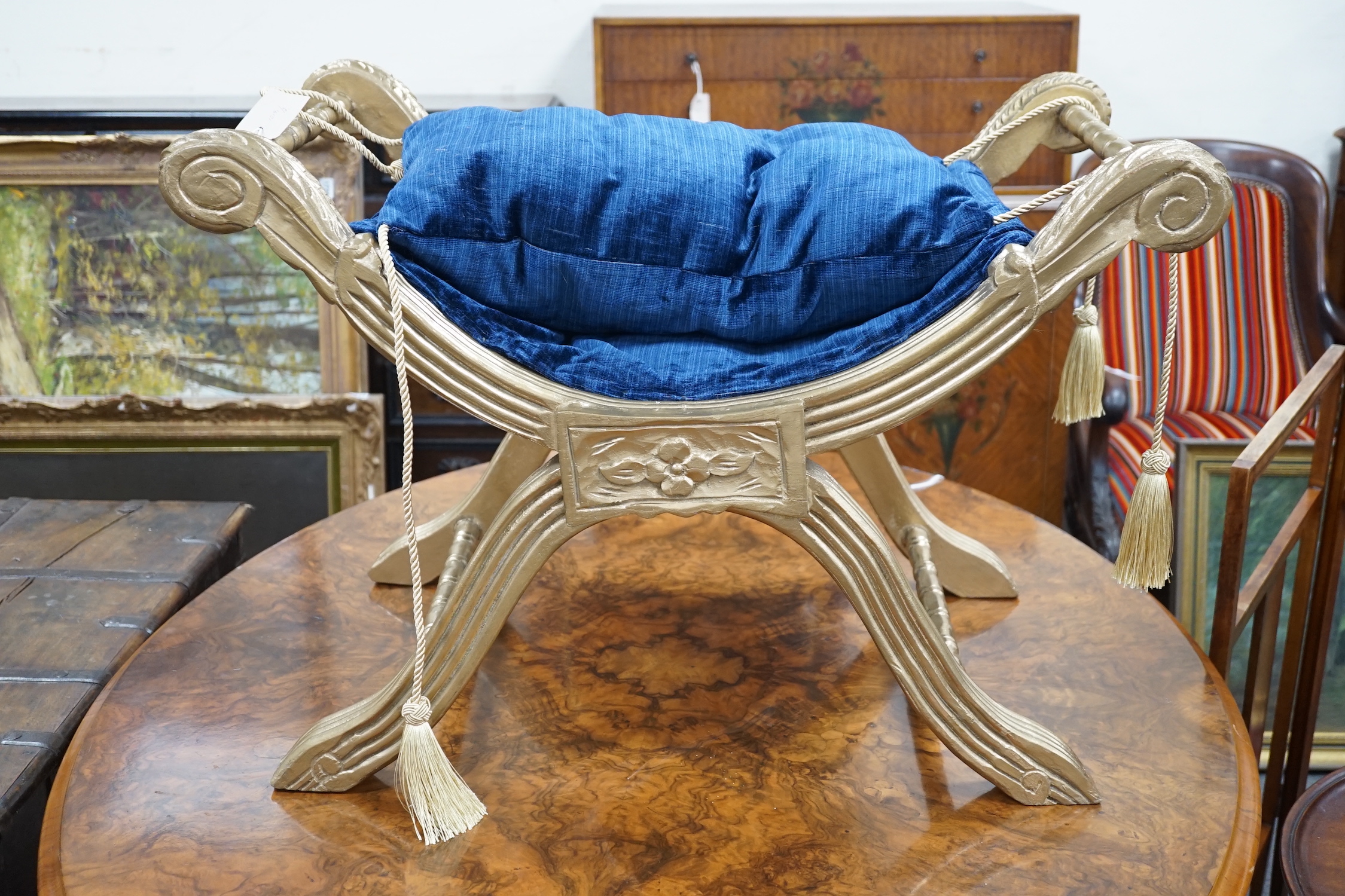 A Regency style carved and fluted giltwood x-frame stool, width 76cm, depth 47cm, height 52cm